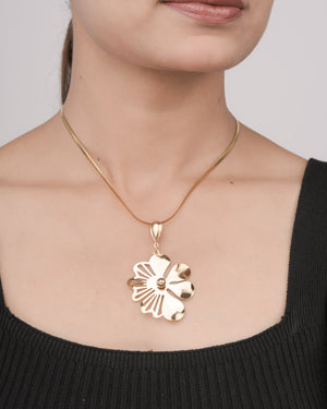 Close-up of woman wearing gold flower pendant necklace on thin chain with black top