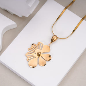 Gold flower pendant on a gold chain necklace displayed on white stand, fashion jewellery